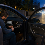 Man installing a night vision system in a car dashboard at night