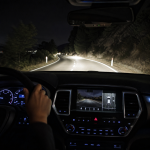 Night driving view from inside an SUV with illuminated dashboard and road ahead