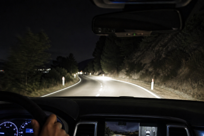 Night driving view from inside an SUV with illuminated dashboard and road ahead