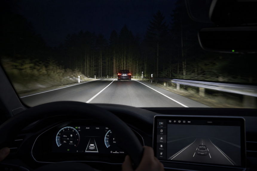 Night driving assistance system active on a forest road viewed from inside a car