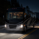Luxury motorhome driving on a scenic road at night with an RV night vision system
