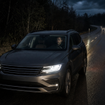 Automotive thermal night vision display showing pedestrians and vehicles on a dark road